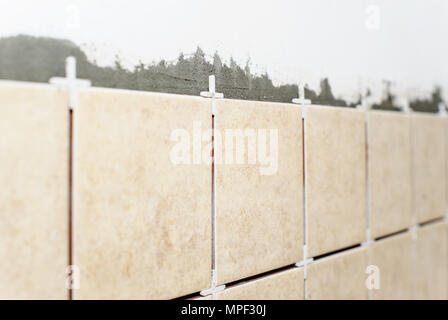 Les carreaux en céramique avec croix en plastique sur le mur de cuisine. Banque D'Images