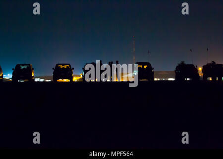 Les soldats de l'armée américaine et portugais affectés au groupement tactique multinational-East Forward Command Post mènent des opérations de nuit de chargement d'élingues au Camp Bondsteel, au Kosovo, le 16 février 2017. À l'aide de lunettes de vision nocturne, les soldats attachent des blocs de béton aux hélicoptères UH-60 Black Hawk pilotés par les équipages de l'armée américaine. La formation améliore l'interopérabilité de l'OTAN, la préparation aux assauts aériens, la coordination opérationnelle, les compétences en aviation de nuit et le soutien logistique pour les missions futures. Banque D'Images