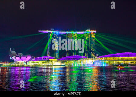 Singapour - Avril 27, 2018 : grand show laser de nuit à Marina Bay Sands Hotel and Casino et musée ArtScience. Lumières du laser sur les eaux de la baie Marina promenade au bord de l'eau à Singapour. Banque D'Images