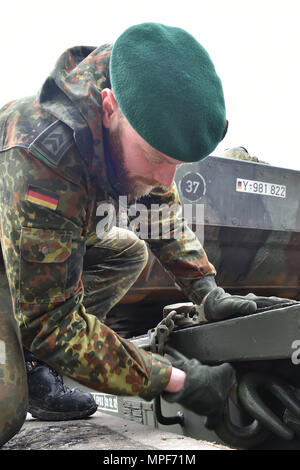 Un soldat allemand avec le 122e Bataillon d'infanterie mécanisée, 12e Brigade blindée, 10. Panzer Division, assure le suivi des véhicules de combat d'infanterie MARDER sur chariots de fer lors de la 7e formation de l'Armée de la commande tour de tête de casernes Grafenwoehr, Allemagne, le 21 février 2017. L'unité envoie aux pays baltes dans le cadre de l'OTAN vers l'amélioration de la présence. (U.S. Photo de l'armée par Visual Spécialiste de l'information, Gertrud Zach) Banque D'Images