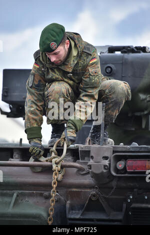 Un soldat allemand avec le 122e Bataillon d'infanterie mécanisée, 12e Brigade blindée, 10. Panzer Division, assure le suivi des véhicules de combat d'infanterie MARDER sur chariots de fer lors de la 7e formation de l'Armée de la commande tour de tête de casernes Grafenwoehr, Allemagne, le 21 février 2017. L'unité envoie aux pays baltes dans le cadre de l'OTAN vers l'amélioration de la présence. (U.S. Photo de l'armée par Visual Spécialiste de l'information, Gertrud Zach) Banque D'Images