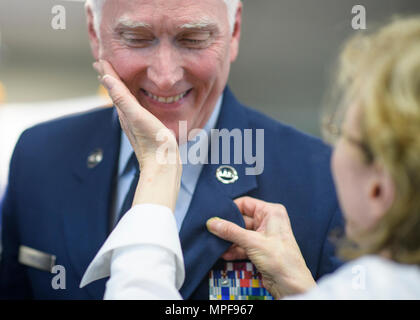 Tracey Kimball, épouse du chef Master Sgt. Tom Kimball, broches Broche la retraite sur son mari après que le directeur général a officiellement pris sa retraite de l'Armée de l'air, 17 févr. 2017 à Buckley Air Force Base, Co. Kimball a servi plus de 24 ans dans l'Armée de l'air. (U.S. Air Force Photo/Tech. Le Sgt. David Salanitri) Banque D'Images