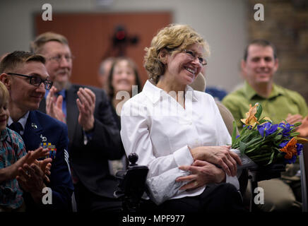 Tracey Kimball, épouse du chef Master Sgt. Tom Kimball, sourit dans l'admiration de son mari comme il donne ses derniers mots lors de la cérémonie de la retraite du chef, le 17 février 2017 à Buckley Air Force Base, Co. Kimball a servi plus de 24 ans dans l'Armée de l'air. (U.S. Air Force Photo/Tech. Le Sgt. David Salanitri) Banque D'Images