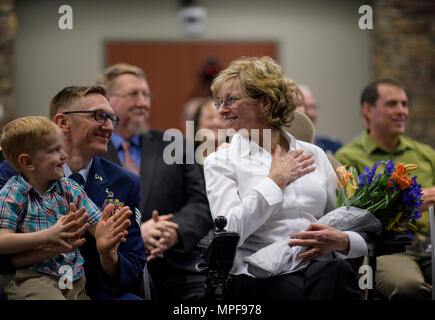 Tracey Kimball, épouse du chef Master Sgt. Tom Kimball, sourit dans l'admiration de son mari comme il donne ses derniers mots lors de la cérémonie de la retraite du chef, le 17 février 2017 à Buckley Air Force Base, Co. Kimball a servi plus de 24 ans dans l'Armée de l'air. (U.S. Air Force Photo/Tech. Le Sgt. David Salanitri) Banque D'Images