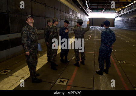 170223-N-RU971-064 SASEBO, Japon (fév. 23, 2017) Le lieutenant J.G. Ray Norris, sous-lieutenant de navire d'assaut amphibie USS Bonhomme Richard (DG 6), explique bien les opérations de pont de marine de la République de Corée, les marins affectés au Commandant, Escadron amphibie (COMPHIBRON) 53, au cours d'un tour de bateau. Bonhomme Richard, l'avant-déployé à Sasebo, au Japon, est au service de l'avant pour avoir une capacité d'intervention rapide en cas de catastrophe naturelle ou d'urgence régionaux. (U.S. Photo par marine Spécialiste de la communication de masse 3 Classe Cameron McCulloch/libéré) Banque D'Images