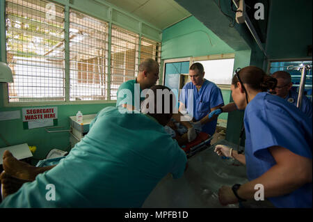Le personnel médical américain et ghanéen déplace un patient avec une lésion de la colonne vertébrale dans la salle d'urgence pendant MEDRETE 17-2 au 37e hôpital militaire, Accra, Ghana. L'exercice comprend des participants de l'armée américaine Afrique, du centre médical de l'armée de Brooke et de la garde nationale du Dakota du Nord. MEDRETE 17-2 fait partie d'une série d'exercices de préparation médicale à travers l'Afrique pour améliorer les compétences cliniques, les soins aux patients et la coopération médicale militaire multinationale. Banque D'Images