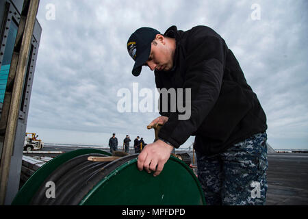 170222-N-OS569-005 Norfolk, Va. (fév. 22, 2017) Maître de Manœuvre Aviation aviateur (manipulation), Joseph Priebe d'Oxford, Maine, brille une buse variable sur le pont du porte-avions USS Dwight D. Eisenhower (CVN 69) (Ike). Ike est en ce moment pier côté pendant la phase de maintien en puissance de la flotte (Plan d'intervention optimisés OFRP). (U.S. Photo par marine Spécialiste de la communication de masse matelot Zach Sleeper) Banque D'Images