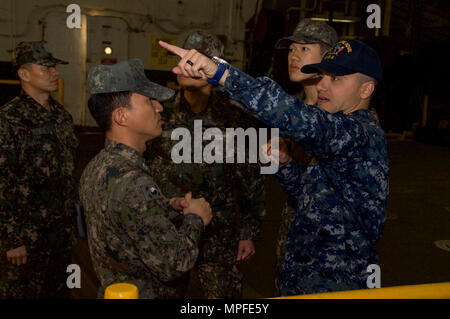 170223-N-RU971-052 SASEBO, Japon (fév. 23, 2017) Le lieutenant J.G. Ray Norris, sous-lieutenant de navire d'assaut amphibie USS Bonhomme Richard (DG 6), explique bien les opérations de pont de marine de la République de Corée, les marins affectés au Commandant, Escadron amphibie (COMPHIBRON) 53, au cours d'un tour de bateau. Bonhomme Richard, l'avant-déployé à Sasebo, au Japon, est au service de l'avant pour avoir une capacité d'intervention rapide en cas de catastrophe naturelle ou d'urgence régionaux. (U.S. Photo par marine Spécialiste de la communication de masse 3 Classe Cameron McCulloch/libéré) Banque D'Images