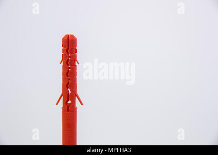 Une cheville en plastique orange sur fond blanc Banque D'Images