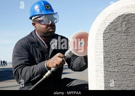 NEWPORT NEWS, Virginie (10 avril 2017) l'Aviation maître de Manœuvre (manutention) Byron 3e classe Mckinnon de Latta, Caroline du Sud, d'une écoutille, sables bitumineux de disque dans le poste de pilotage à bord de la classe Nimitz porte-avions USS ABRAHAM LINCOLN (CVN 72). Abraham Lincoln est à l'étape finale d'un ravitaillement de quatre ans et complexe de révision et seront livrés à la flotte au début de 2017. Banque D'Images