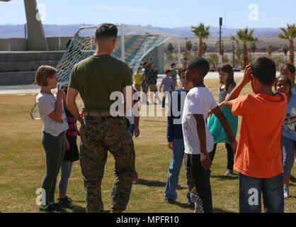 Marines avec 3e Bataillon, 4e, 7e Régiment de Marines Marines interagir avec les quatrième et cinquième année d'études de l'école élémentaire de Palm Vista au Parc de la Victoire au Parc de la victoire après la bataille annuelle cérémonie couleur à lance le Cpl. À bord champ Torrey Marine Corps Air Ground Combat Center, Twentynine Palms, Californie, le 8 mars 2017. L'école primaire 3/4 adoptée afin d'encadrer les enfants. (U.S. Marine Corps photo par Lance Cpl. Natalia Cuevas) Banque D'Images