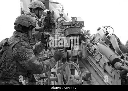 La CPS. Christopher Rios (haut), # 2 l'homme et le Sgt. Mack Olsen, Gunner, toutes deux membres de l'équipe du canon pour la 1ère section, 1e Peloton, Cobra, de la batterie, de l'Escadron d'artillerie régiment de cavalerie 2d, de l'armée américaine, de mener une mission de tir avec leur M777A2 Howitzer lors d'un 8 mars, 2017 dans la zone d'entraînement Grafenwoehr, Allemagne. L'Escadron a participé à l'avant dynamique II 6-9 mars, 2017. L'exercice a permis aux États-Unis, l'Allemagne et la République tchèque pour synchroniser leurs capacités d'artillerie. (Photo : Le s.. Jennifer Bunn, régiment de cavalerie 2d Affaires publiques) Banque D'Images