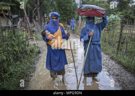 2 septembre 2017 - Cox's Bazar, Chittagong, Bangladesh - DIL, 30 Newaz, tenant son enfant âgé d'un an et 40 Nazma Begum, du Myanmar, qui ont traversé la frontière vers le Bangladesh le 2 septembre 2017, après trois jours de marche pour échapper à la violence dans leur village.dans un voyage épuisant à traverser en sécurité, les plus fortes portent le plus faible de l'humidité des rizières et des pluies de mousson. La pluie est lourd et fréquent, et rend le sol humide et boueux, incroyablement rendant ainsi encore plus difficile de marcher à travers. Le voyage jusqu'au Bangladesh a été difficile pour les réfugiés rohingyas, en particulier Banque D'Images