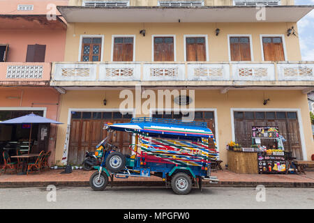 Trois-roues colorés taxi appelé jumbo (ou tuk-tuk) en face d'un vieux bâtiment de l'époque coloniale française sur l'Kingkitsarath Road à Luang Prabang, Laos Banque D'Images