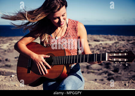 Beau portrait féminin en activité de loisirs piscine en plein air avec une guitare acoustique et de l'océan en arrière-plan. La liberté d'été rebelle à tenerife concept Banque D'Images