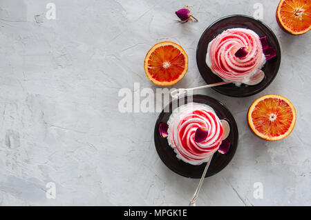 L'eau de rose orange sanguine et glace vanille servie sur une assiette. Arrière-plan de pierre blanche. Banque D'Images