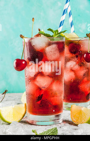 Glacé d'un rafraîchissement, Cherry Cola limonade ou mojito cocktail au grand verre, sur fond gris et bleu clair copy space Banque D'Images