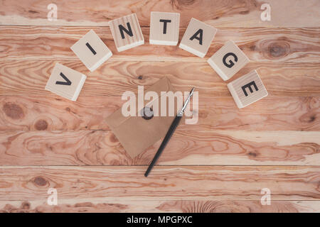 Vue de dessus de cubes avec des lettres, enveloppe avec joint et stylo sur fond de bois Banque D'Images