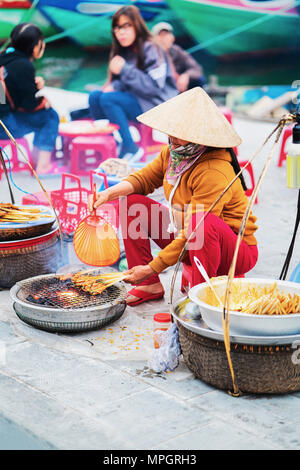 Hoi An, Vietnam - 16 Février 2016 : femme vendant des morceaux de viande frits dans la rue market à Hoi An, Vietnam Banque D'Images