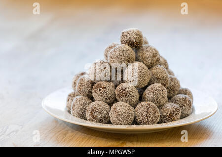 Assiette remplie de billes de chocolat fait maison recouvert de flocons de noix de coco râpée Banque D'Images
