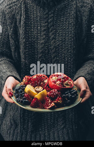 Femme tenant la plaque avec des fruits dans les mains Banque D'Images