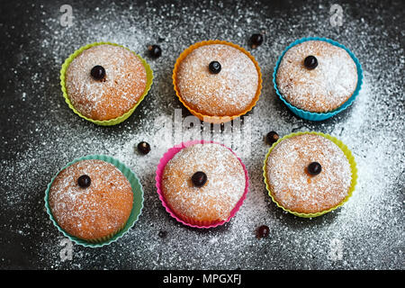 Muffins aux cassis en formes silicone saupoudrée de sucre en poudre Banque D'Images