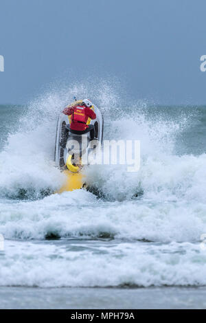 Un sauveteur RNLI équitation un jetski sauvetage à Newquay en Cornouailles dans Fistral.. Banque D'Images