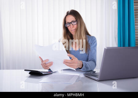 Close-up of young Businesswoman Reading Document in Office Banque D'Images