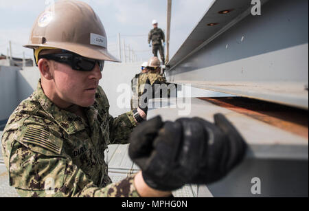 Constructionman Builder Apprentice Travis Durr, affectés à la construction navale, 5 Bataillon Mobile guides une poutre en I à la République de Corée (ROK) l'éducation et de la formation navale en commande Jinhae, Corée, le 14 mars 2017, dans le cadre de l'exercice Foal Eagle 2017. Foal Eagle est un exercice d'entraînement bilatéral annuel, conçu pour améliorer l'état de préparation des forces des États-Unis et de la République de Corée et de leur capacité à travailler ensemble durant une crise. (U.S. Caméra de combat de la marine photo de Mass Communication Specialist 1re classe Torrey W. Lee) Banque D'Images