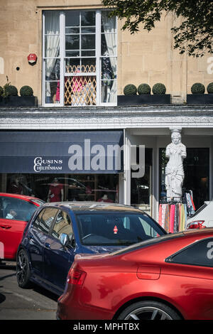 Les piétons circulant le long de la rue à l'extérieur de la façade noir boutiques et bars sur la promenade près de Montpellier, Cheltenham, Gloucestershire. Banque D'Images