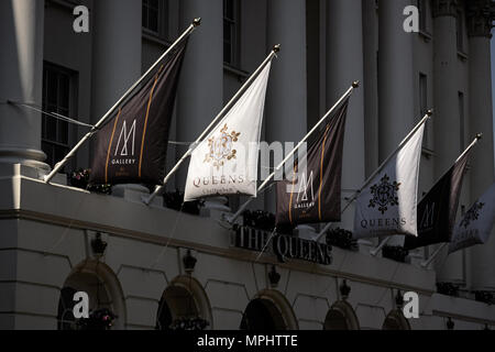 Les drapeaux sur le soleil au-dessus de l'entrée principale de l'hôtel Queens, Cheltenham, Gloucestershire. Banque D'Images