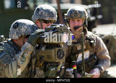 Un feu de l'armée américaine spécialiste des contrôles avec la 101st Airborne Division (Air Assault) utilise un télémètre désignateur laser léger 2H pour fournir un appui-feu acquisition d'objectifs et de reconnaissance au cours de l'appui aérien rapproché avec la formation des pilotes aux commandes d'un AH-1W Super Cobra hélicoptère de combat et d'un hélicoptère UH-1Y Venom au cours de l'exercice guerrier 78-17-01 le 17 mars, 2017 at Joint Base McGuire-Dix-Lakehurst. Contrôles d'incendie affectés au siège de spécialiste et le Siège Batterie, 3e Bataillon, 320e Régiment d'artillerie, avec la direction de la Société A (Société simple), 2e Batt Banque D'Images
