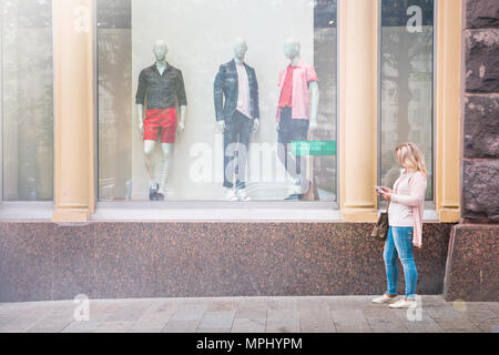 Moscou, Russie, le 22 mai. 2018 : la jeune fille debout à la vitrine de la célèbre marque. Banque D'Images