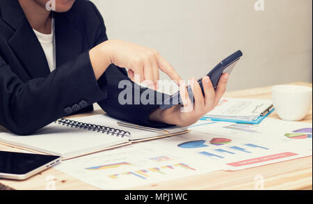 Businesswoman poussant et agissant sur la calculatrice et à la recherche d'affaires sur papier, concept finance sur table Banque D'Images