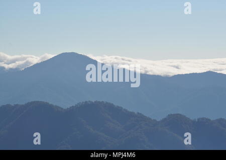 Nuages couvrant les crêtes des montagnes de la Cordillère campagne au petit matin vue depuis le mont Ulap lors de notre journée de randonnée sur l'ÉCO-TRAIL. Banque D'Images