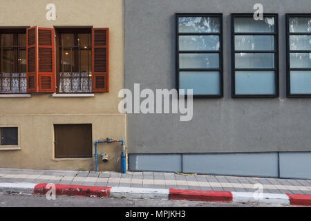 Les murs des deux maisons sont très proches les uns des autres : sur le côté gauche il y a un mur jaune vintage avec volets roulants, sur métal-plastique moderne droit windows Banque D'Images