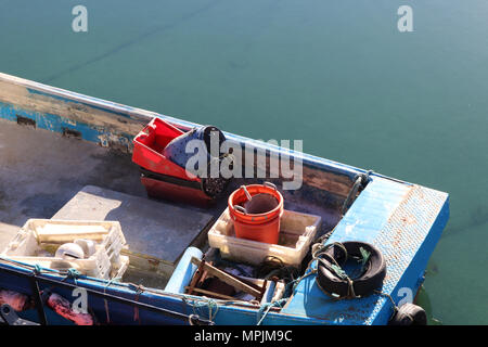 Close up de fronts d'un petit rouge et un petit homard bleu bateau dans port avec reflets d'arcs dans l'eau Banque D'Images