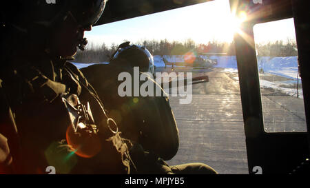 Le Sgt. Ty Morgan (à gauche) et le Cpl. Landon joue (centre) veille à l'arrière d'un UH-1Y Venom comme il décolle pour effectuer les opérations par temps froid à bord Fort Drum, N.Y., 17 mars 2017. Marines affectés à l'Escadron d'hélicoptères d'attaque légère Marine, Marine 269 Groupe d'aéronefs 29, 2nd Marine Aircraft Wing, mené l'appui aérien rapproché de nuit avec des munitions réelles pour simuler des missions dans une position avancée. Morgan et ses joues sont des chefs d'équipage avec HMLA-269. (U.S. Marine Corps photo par le Cpl. Gibson Mackenzie/libérés) Banque D'Images