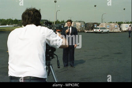 Un analyste de nouvelles est enregistré par un caméraman pour un briefing ou un reportage mené par l'Agence américaine pour le développement international. Le cadre semble être à l'intérieur avec un équipement vidéo professionnel, y compris des caméras et de l'éclairage. L'analyste fournit des informations ou des commentaires sur les opérations de l'USAID, les efforts humanitaires ou les programmes de développement international. L'image capture la documentation médiatique, les reportages professionnels et la communication d'informations factuelles au public concernant les initiatives de développement soutenues par le gouvernement américain. Banque D'Images
