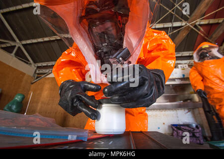 Membre de l'équipe de grève Le Sgt. Joe Bercovic avec le New Jersey 21 de la Garde nationale d'armes de Destruction-Civil l'équipe de soutien, les joints d'une preuve de l'échantillon avec bande anti-altération pendant un exercice avec le service d'incendie de Picatinny Arsenal au New Jersey la défense de la patrie (Homeland Security Center à Picatinny Arsenal, N.J., 23 mars 2017. Le 21e ADM-CST est un groupe mixte composé de soldats de la Garde nationale du New Jersey et les aviateurs dont la mission est d'aider les autorités civiles en identifiant les substances chimiques, biologiques, radiologiques et nucléaires dans d'origine humaine ou d'une catastrophe naturelle Banque D'Images