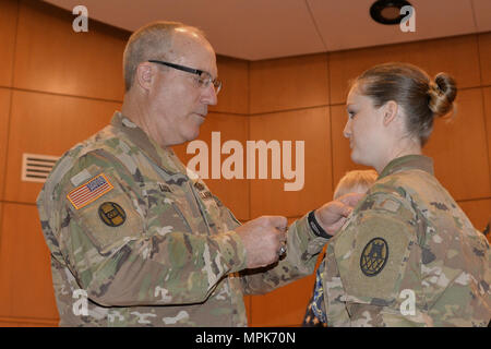 Caroline du soldat de la Garde nationale de la CPS. Semantha Bunce, droite, est honorée avec le soldat de l'Aviateur NCNG et médaille (NCSAM) lors d'une cérémonie à l'administration centrale de la Garde côtière dans la région de Raleigh, 24 mars 2017. "Nous avons besoin d'un moyen de reconnaître ceux qui vont au-delà de l'armée", a déclaré le Major-général Greg Lusk, l'adjudant général de la Caroline du Nord, commandant de l'NCNG, gauche. Bunce sert avec le 105e bataillon du génie de l'administration centrale. En novembre 2015, deux des assaillants armés ont fait irruption dans sa maison. Elle a manoeuvré par les tirs et l'engagea les intrus avec sa propre arme à feu blessant un de ses agresseurs et d'être blessés durin Banque D'Images