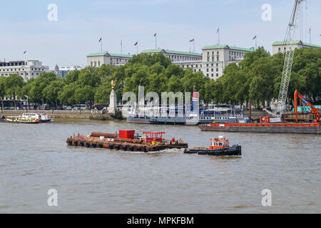 L'Illyrie GPS remorqueur tire une barge la livraison des matériaux de construction par Victoria Embankment estran sur la Tamise à Londres Banque D'Images