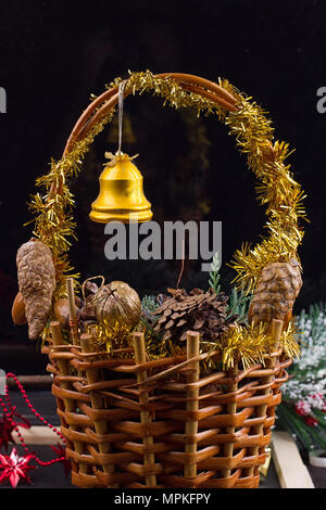 Ornements de Noël avec Guirlande de perles, des pommes de pin et glands portant dans un panier avec des greens Banque D'Images