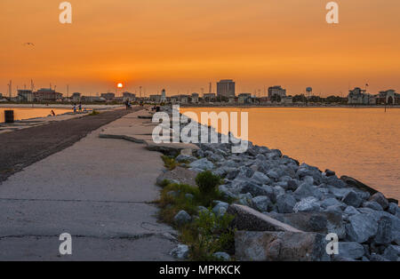 Des dalles de béton brisées sur la jetée de roche au coucher du soleil dans la marina municipale de Gulfport à Gulfport, Mississippi Banque D'Images