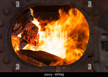 Feu brûler dans une chaudière à vapeur en métal pour produire de l'énergie pour faire fonctionner l'équipement de scierie. Bois de rebut à partir de l'usine fournit une source de combustible pour la cuisson des t Banque D'Images