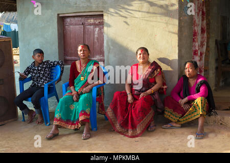 Les népalaises de l'ethnie Tharu assis en face d'une maison pendant un mariage, Chitwan, Népal Banque D'Images