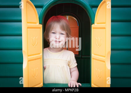 18 mois, fille, enfant jouant dans sa play house Banque D'Images
