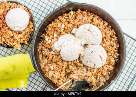 La rhubarbe cuite faits maison et crumble aux pommes avec glace à la vanille et à l'avoine dans le fer à repasser Cuisine Banque D'Images