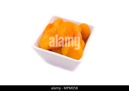 Abricots dénoyautées sur bol carré sur fond blanc Banque D'Images