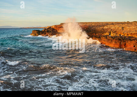 Les pêcheurs côtiers et déferlante près de Cala Saona avec plage punta Gavina tower dans la distance à Formentera (Baléares, Espagne) Banque D'Images